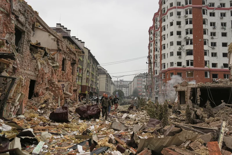 People walk near apartment buildings damaged by a Russian attack in Kyiv.