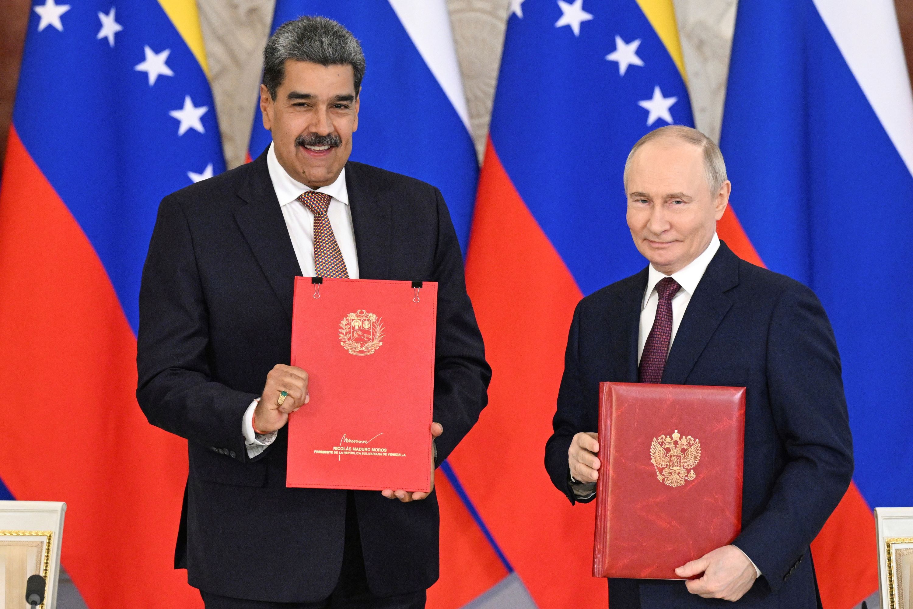 Venezuelan President Nicolas Maduro (left) and Russian President Vladimir Putin attend a signing ceremony.